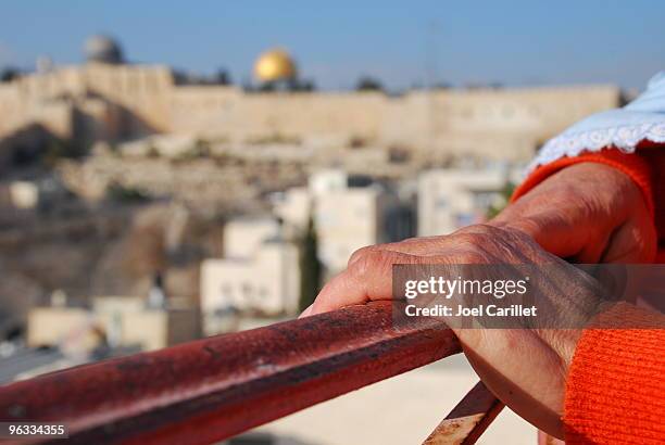woman's hands on railing overlooking jerusalem's old city - palestinian stockfoto's en -beelden