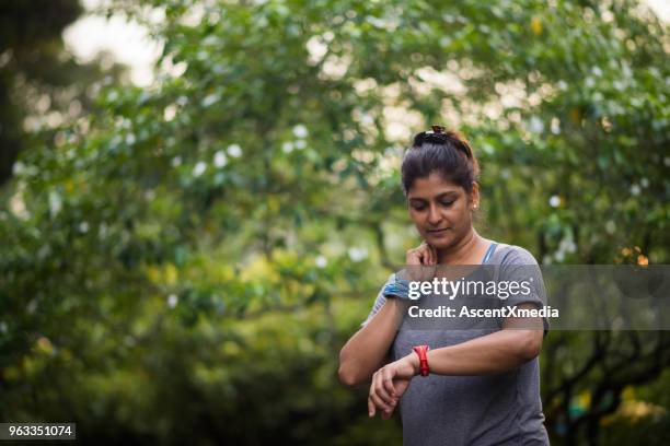 active senior woman enjoying a healthy lifestyle - taking pulse stock pictures, royalty-free photos & images