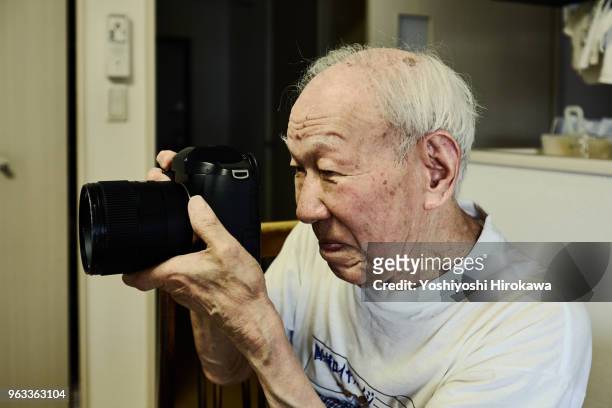 healthy senior who enjoys taking pictures with the latest luxury digital single-lens reflex camera on shonan coast - chigasaki stock pictures, royalty-free photos & images