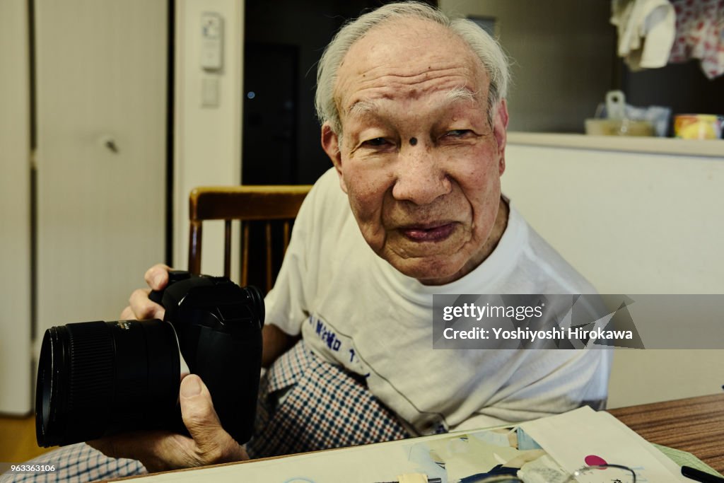 Healthy senior who enjoys taking pictures with the latest luxury digital single-lens reflex camera on Shonan Coast