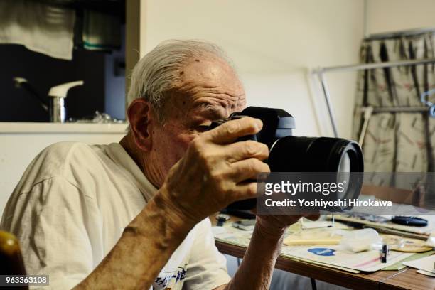 healthy senior who enjoys taking pictures with the latest luxury digital single-lens reflex camera on shonan coast - chigasaki stockfoto's en -beelden