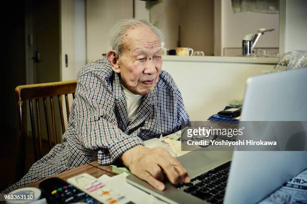 healthy senior who enjoys internet with laptop computer - chigasaki stock pictures, royalty-free photos & images