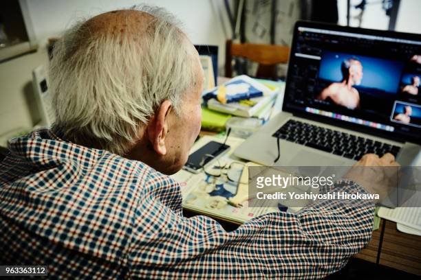healthy senior who enjoys internet with laptop computer - chigasaki stockfoto's en -beelden