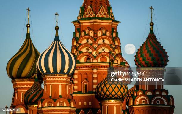 Picture shows the moon over Saint Basil's Cathedral on the Red Square in Moscow on May 28, 2018.