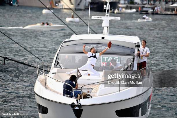 Daniel Ricciardo of Australia and Red Bull Racing catches a ball thrown by NFL star Tom Brady on the TAG Heuer boat after qualifying for the Monaco...