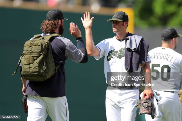 Cleveland Indians pitcher Adam Plutko gets a high-five from Cleveland Indians pitcher Ben Taylor as he walks in from the bullpen prior to the Major...