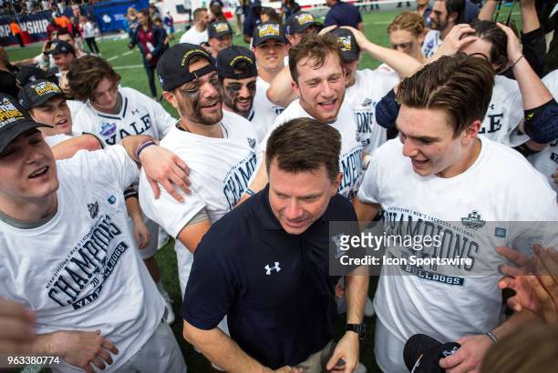 Yale Bulldogs players celebrate with Yale Bulldogs head coach Andy Shay at the conclusion of the NCAA Division I Men's Championship match between...
