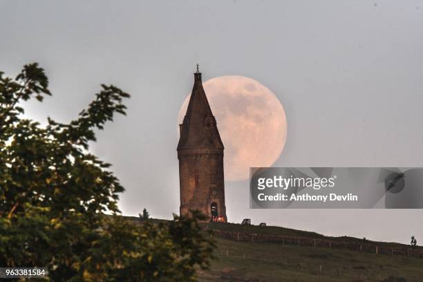 Group of people sit at the base of Hartshead Pike as the Flower Moon rises at 98.6% on May 28, 2018 in Manchester, England. The tower was rebuilt in...