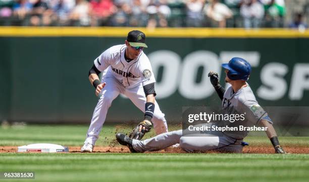 Shortstop Andrew Romine of the Seattle Mariners tags out Ryan Rua of the Texas Rangers at second base after Rua tried to stretch a single to a double...