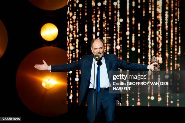 French actor Jean-Pierre Darroussin holds his trophy after winning a 'Moliere' in the category 'comedien dans un spectacle de theatre prive' during...