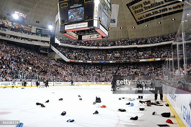 Fans toss their hats on the ice after Sidney Crosby of the Pittsburgh Penguins scores a hat trick in the second period against the Buffalo Sabres on...