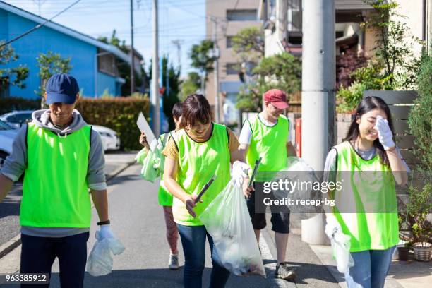 gruppe von freiwilligen, die reinigung von straßen in tokio - city cleaning stock-fotos und bilder