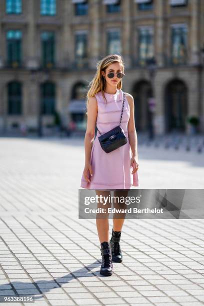 Rosa Crespo, fashion blogger, wears Quay sunglasses, a pink Dior dress with embroidery, a Chanel black leather bag, on May 27, 2018 in Paris, France.