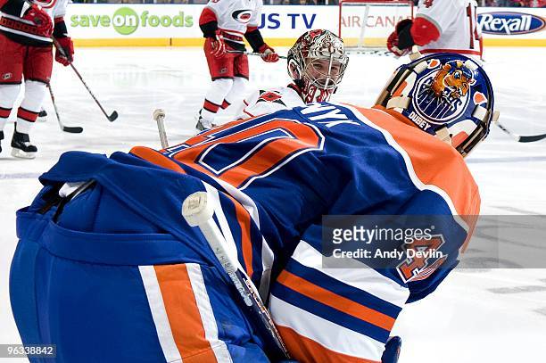 Devan Dubnyk of the Edmonton Oilers and Cam Ward of the Carolina Hurricanes chat and laugh during warm-up before a game at Rexall Place on February...