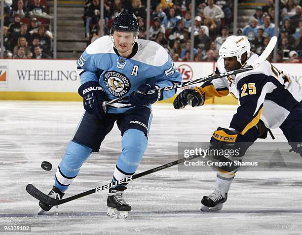 Sergei Gonchar of the Pittsburgh Penguins battles for the puck against Michael Grier of the Buffalo Sabres on February 1, 2010 at Mellon Arena in...