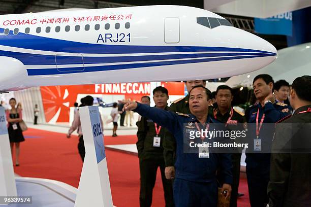 Attendees look at a model of the Commercial Aircraft Corp. Of China ARJ21 airplane at the Singapore Airshow, in Singapore, on Tuesday, Feb. 2, 2010....