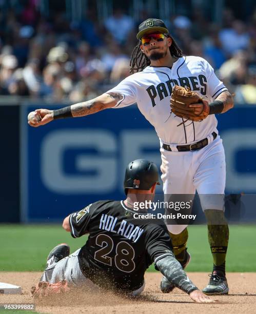 Freddy Galvis of the San Diego Padres throws over Bryan Holaday of the Miami Marlins as he turns a double play during the seventh inning of a...