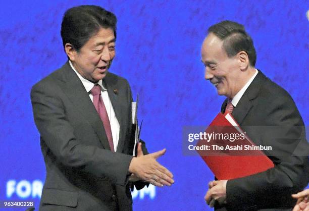 Japanese Prime Minister Shinzo Abe and Chinese Vice President Wang Qishan shake hands after the St. Petersburg International Economic Forum on May...
