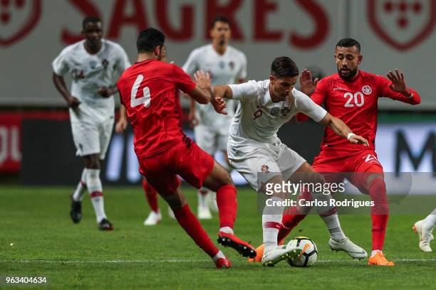 Portugal and AC Milan forward Andre Silva vies with Tunisia defender Yassine Meriah and Tunisia midfielder Ghaylen Chaaleli for the ball possession...
