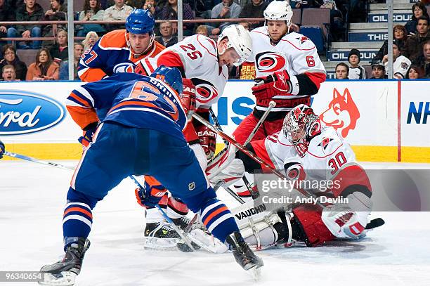 Dustin Penner and Gilbert Brule of the Edmonton Oilers fight for the puck while Cam Ward, Joni Pitkanen and Tim Gleason of the Carolina Hurricanes...