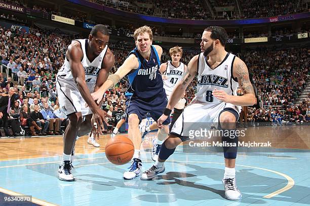 Paul Millsap and Deron Williams of the Utah Jazz battles for the loose ball with Dirk Nowitzki of the Dallas Mavericks at EnergySolutions Arena on...