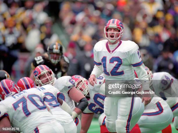 Quarterback Jim Kelly of the Buffalo Bills calls out a play at the line of scrimmage as he stands near offensive linemen John Fina, Ruben Brown, Adam...