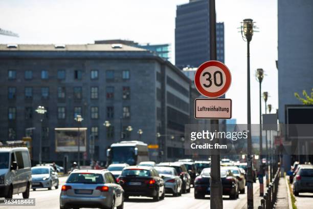 cars drive past a sign of speed limit in berlin, leipziger strasse (germany) - luftverschmutzung stock-fotos und bilder