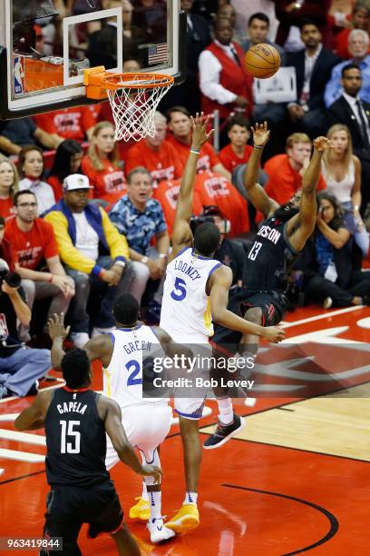 James Harden of the Houston Rockets goes up against Kevon Looney and Draymond Green of the Golden State Warriors in the first quarter of Game Seven...