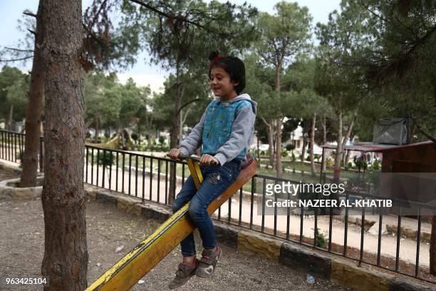 Syrian child displaced from Eastern Ghouta play in a park in Afrin on May 5, 2018. Displaced from their homes in Syria's Eastern Ghouta, families...