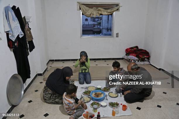 Syrian man Mehdi Haymur and his family, wife Raifa, son Saad, daughter Inas and son Mohamad share a meal in Afrin, on May 26, 2018. Displaced from...