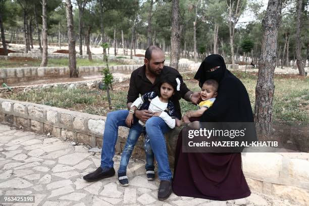 Years-old Fras Abou Al-Kheir sits with his wife Umaima al-Sheikh , 25 years old and their children in Afrin on May 5, 2018. Displaced from their...