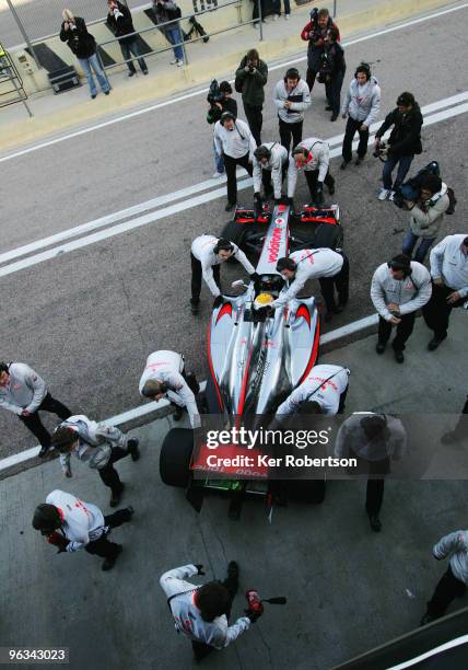 Lewis Hamilton of Great Britain and McLaren Mercedes is pushed back into his team garage after driving the new McLaren MP4-25 for the first time,...