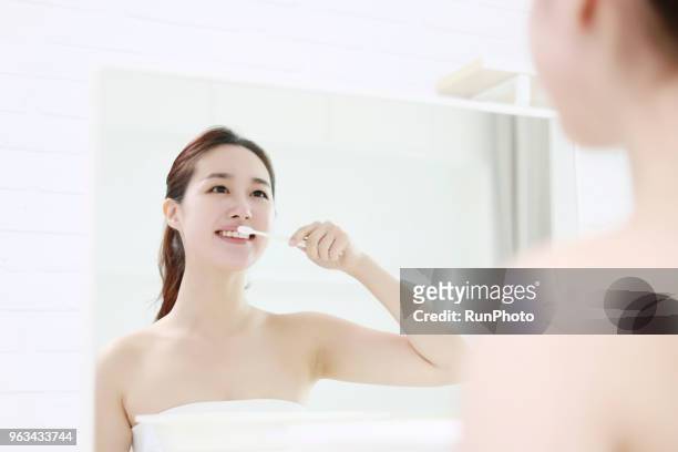 young woman brushing teeth - toothbrush ストックフォトと画像