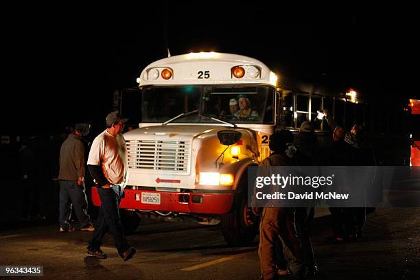 Union workers slow a bus filled with replacement workers leaving the front gate of the Rio Tinto Borax mine on the day after mine owners locked out...