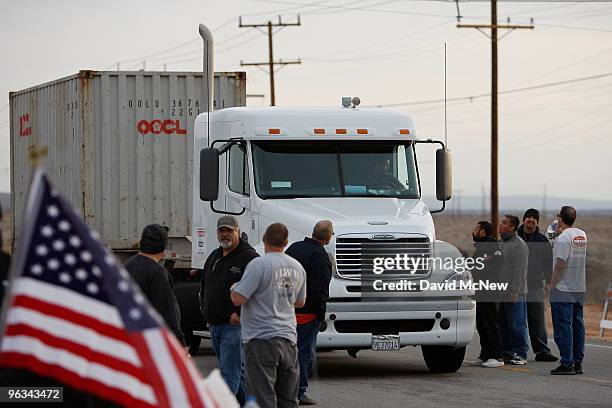 Union workers slow a truck entering the front gate of the Rio Tinto Borax mine on the day after mine owners locked out about 540 employees and called...