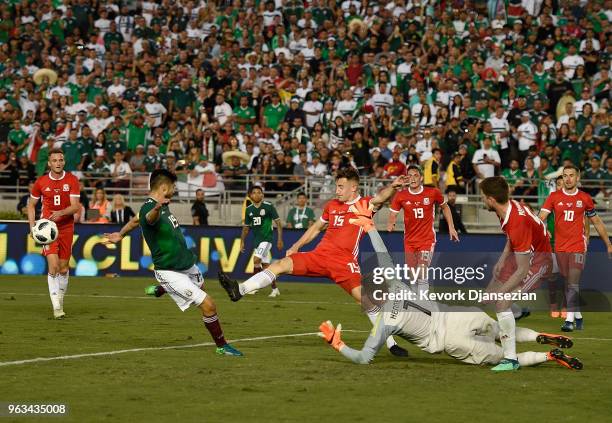 Tom Lockyer of Wales clears the ball before Oribe Peralta of Mexico attempts to score with goalkeeper Wayne Hennessey of Wales defending during the...