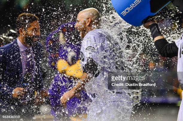 Chris Iannetta of the Colorado Rockies receives an ice bath from Charlie Blackmon of the Colorado Rockies after hitting a 10th inning walk-off single...