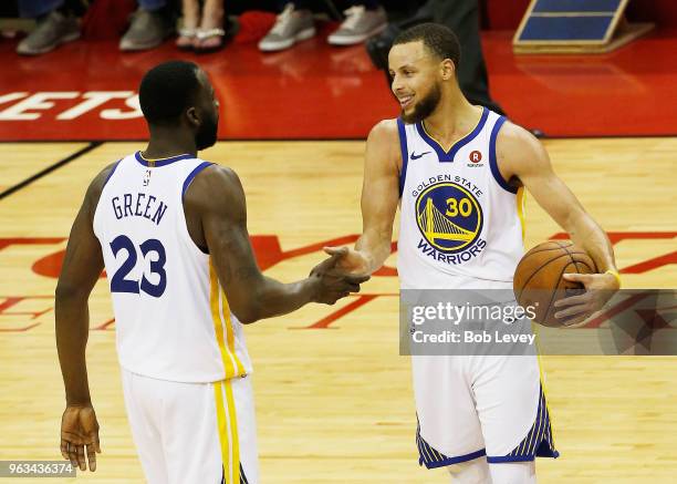 Stephen Curry and Draymond Green of the Golden State Warriors celebrate after they defeated the Houston Rockets 101 to 92 in Game Seven of the...