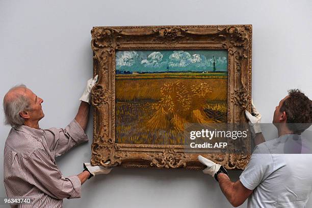 Employees install on April 18, 2009 the painting "Wheat Field with Sheaves" by Dutch artist Vincent van Gogh part of the exhibition "Vincent van Gogh...