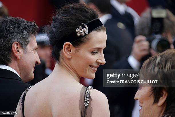 French actress Juliette Binoche looks at fellow actress Annie Girardot as they arrive for the screening of Austrian director Michael Haneke's film...