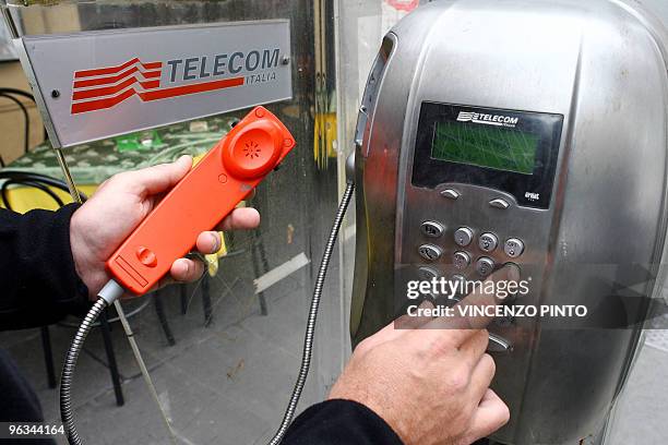 Man dials on a Telecom Italia public telephone in the center of Rome 04 April 2007. German telecommunications giant Deutsche Telekom declined to...