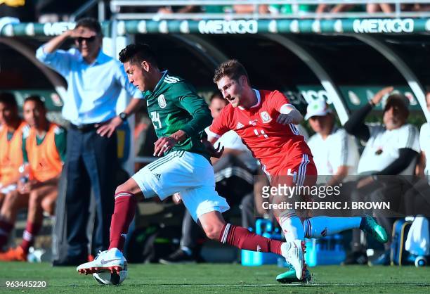 Mexico coach Carlos Osorio watches from the sideline as Edson Alvarez of Mexico gets past Ben Davies of Wales during their international soccer...