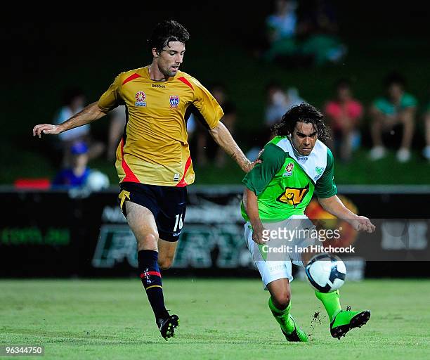 David Williams of the Fury kicks the ball past Jason Hoffman of the Jets during the round 25 A-League match between North Queensland Fury and the...