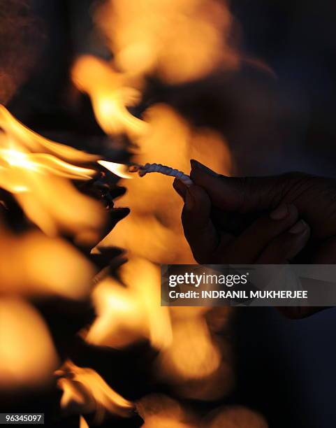 Sri Lankan Buddhist devotee lights a wick after offering prayers on Poya-full moon at the Kelaniya Temple in Kelaniya, Gampaha district on January...