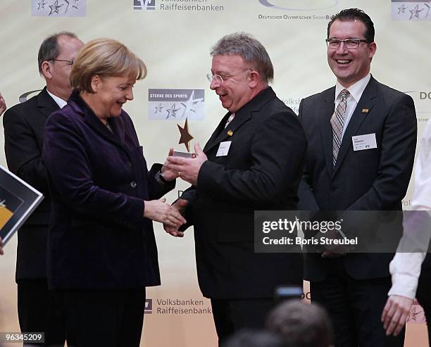 German Chancellor Angela Merkel hands out the 'Grossen Stern des Sports in Gold 2009' award to Klaus Wehowsky of Polizeisportverein Saar and Edgar...