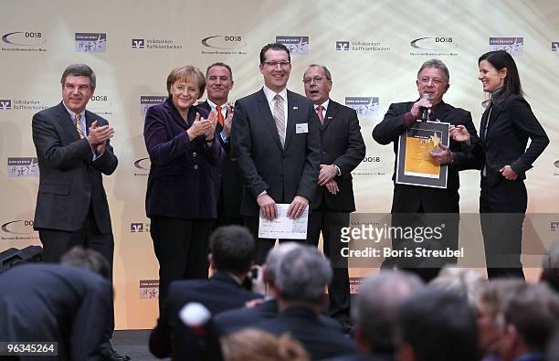 Thomas Bach , president of the German Olympic Sports Federation, German Chancellor Angela Merkel and Katrin Mueller-Hohenstein of the ZDF applaud...
