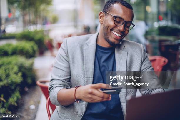 man in coffee shop using laptop - small business saturday stock pictures, royalty-free photos & images