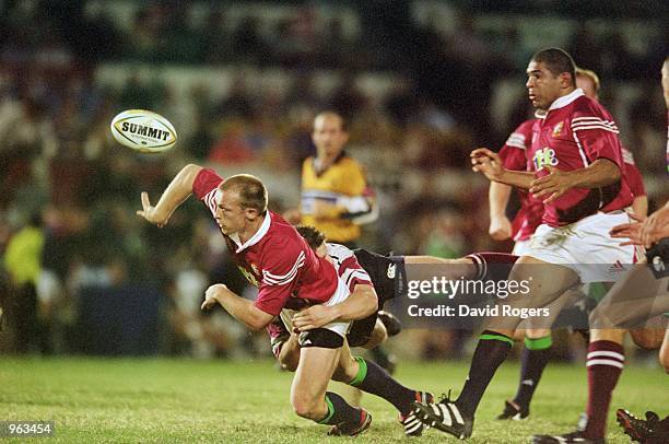 Matt Dawson of the British Lions manages to pass the ball despite being under pressure during the Tour Match against Queensland Presidents XV played...