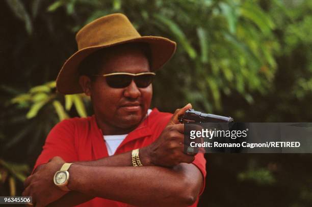 Colombia, marijuana dealer practising shooting his gun on the hills behing Guajira coast.