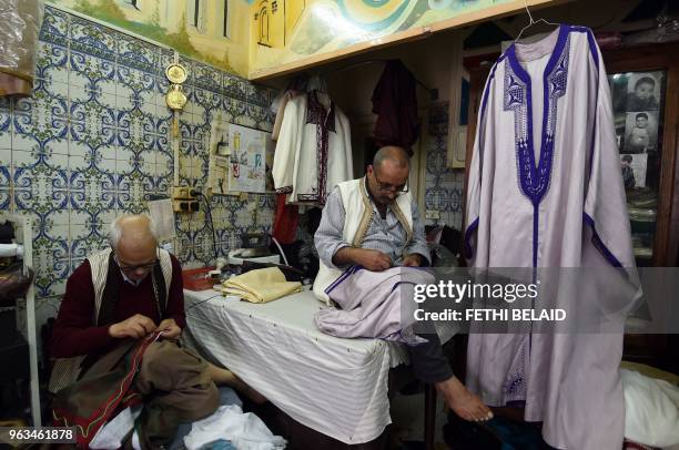 Picture taken on May 21 shows Mohamed and Habib stitching a Jebba at a store in the capital Tunis.